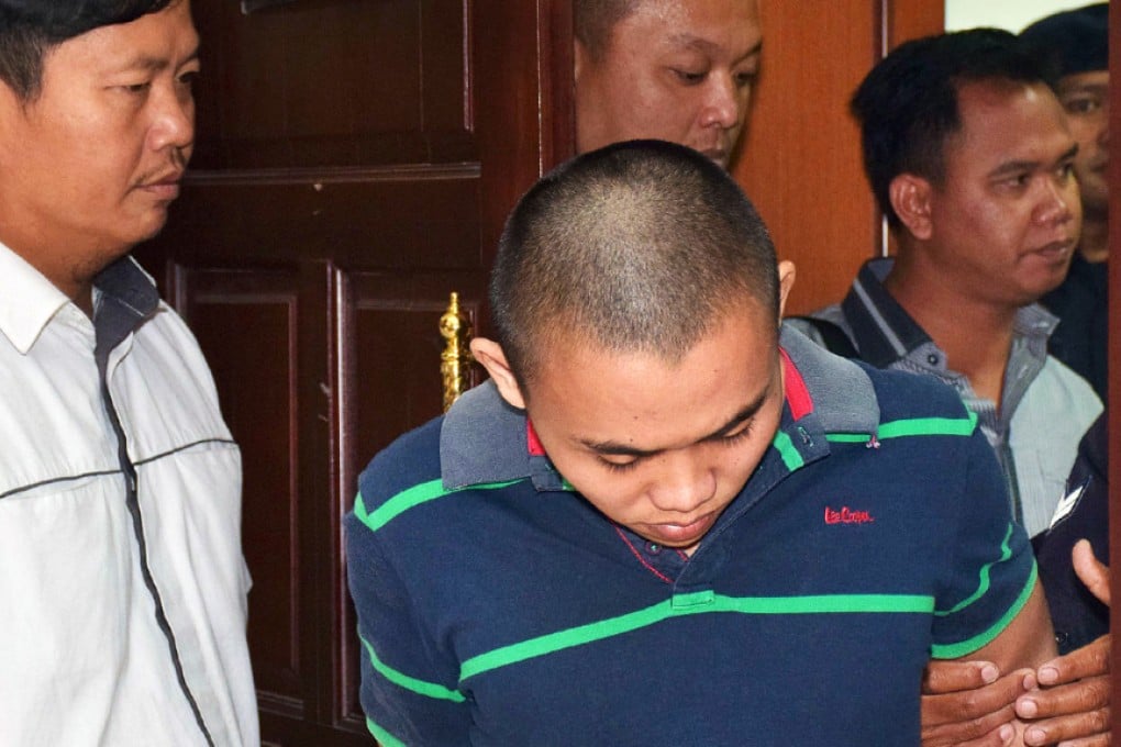 Zulkipli Abdullah (left) is escorted to the high court in Sarawak. He was found guilty of stabbing two foreigners dead. Photo: Reuters