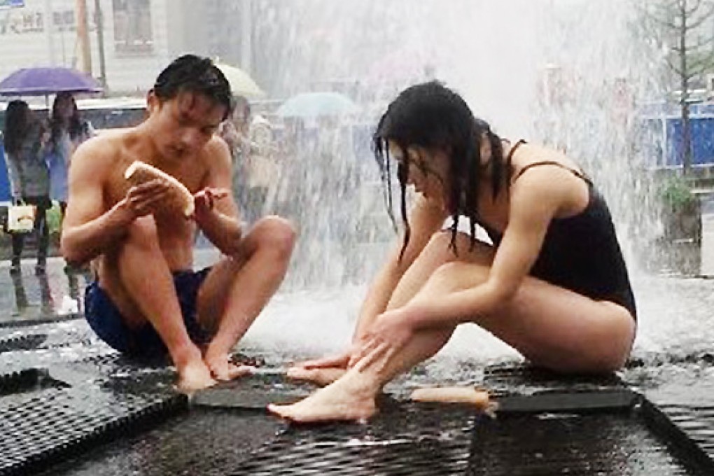 A couple drew attention when they wore only their bathing suits while they took a shower in Wuhan's landmark Guanggu Square. Photo: Sina Weibo