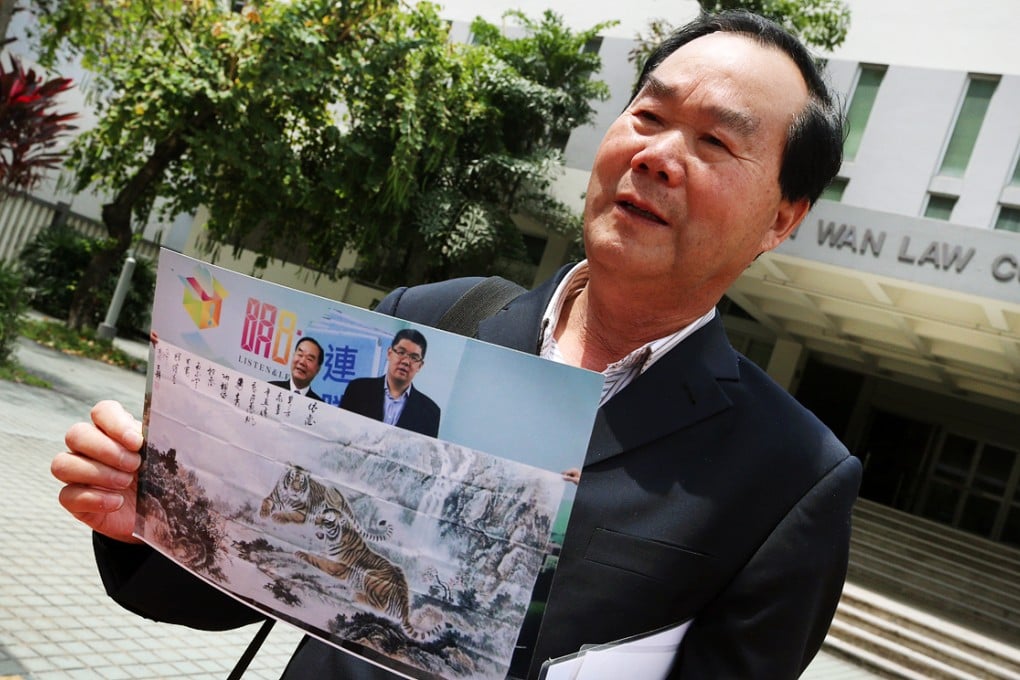 Lee Yuet-fung shows off one of his paintings outside court. Photo: David Wong