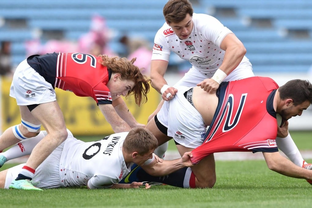 Jack Capon is held up by England's Josh Watkins and Alex Gray, while Hong Kong debutant Hugo Stiles provides support at the Japan Sevens. Photos: AFP