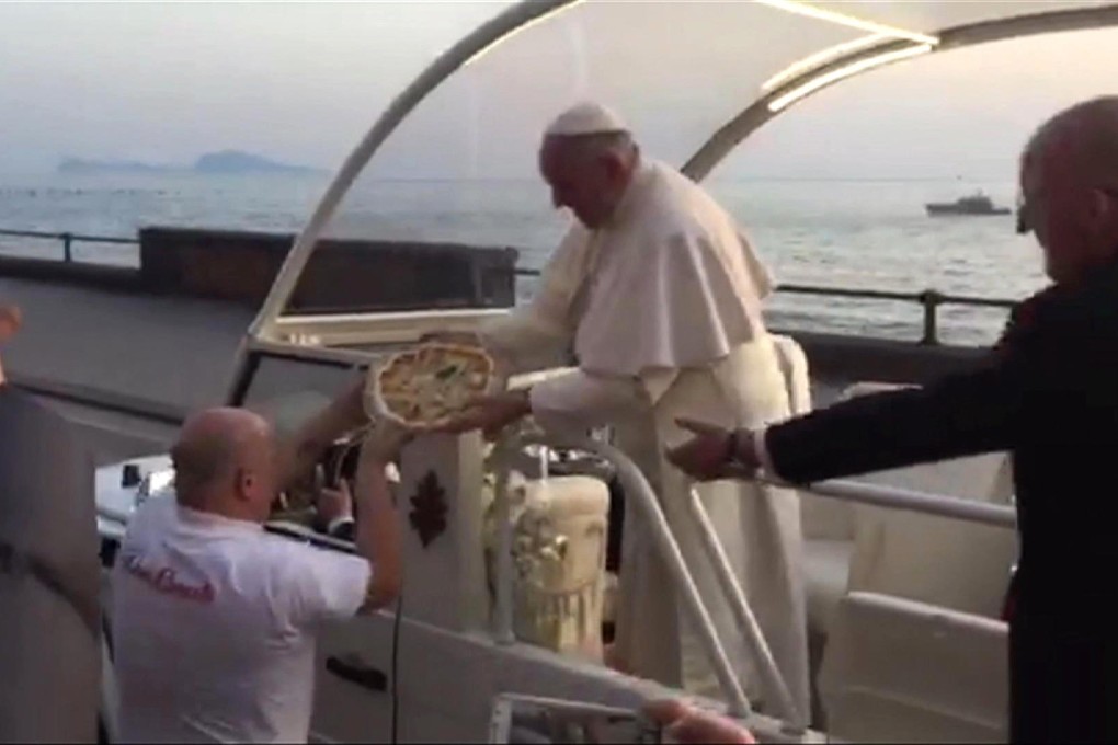 Pope Francis receives a pizza delivery as his boat went by the Naples waterfront during a one-day visit to the Italian city.Photo: AP