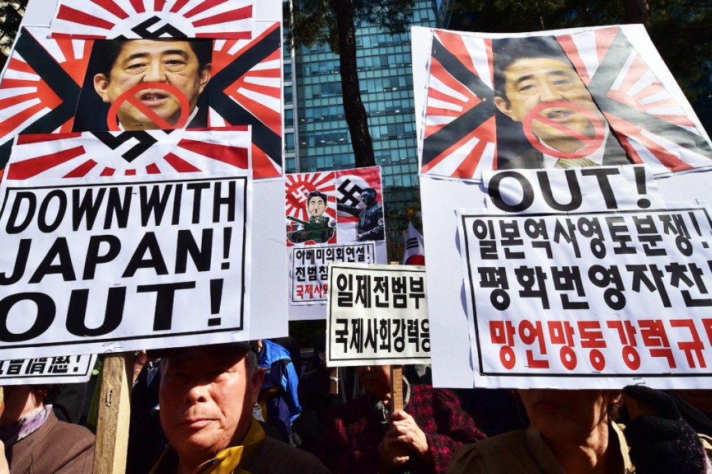 South Korean protestors hold placards showing portraits of Japan's Prime Minister Shinzo Abe during an anti-Japan rally outside the Japanese embassy in Seoul on April 1, 2015. Photo: AFP
