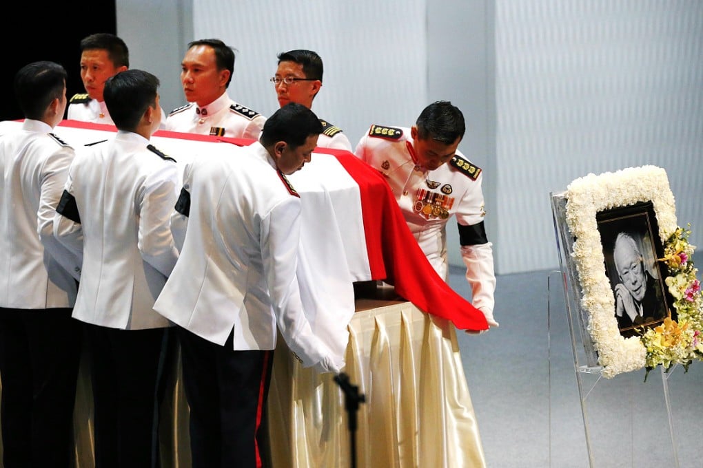 Pallbearers adjust the national flag of Singapore covering the coffin of Lee Kuan Yew during a state funeral held at the University Cultural Center, in Singapore on March 29, 2015. Members of the public queue to pay their respects to Lee. Photo: AP