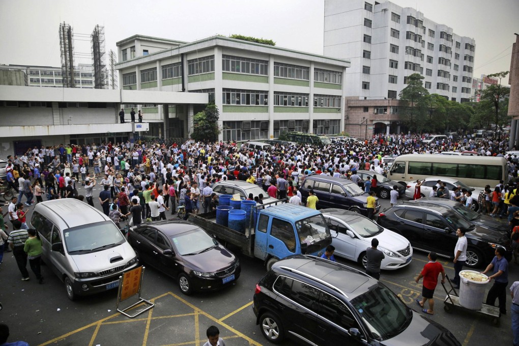 Workers protest during a strike as police stand guard at a Yue Yuen Industrial factory in Dongguan, Guangdong province, in April, 2014. Photo: Reuters