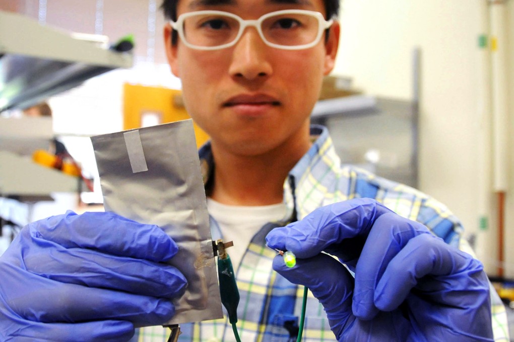 A researcher from Stanford University shows a newly developed aluminium battery supplying electricity to a LED light. Photo: Xinhua