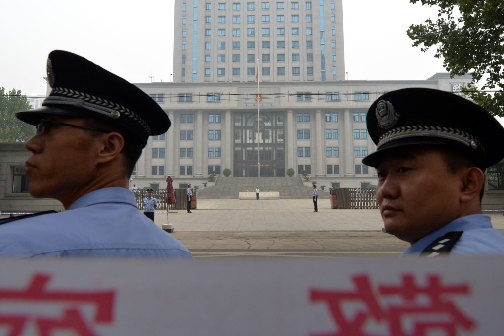 Police stand guard outside the Intermediate People's Court in Jinan, Shandong. For judges to be credible, neutrality is crucial. Photo: AFP