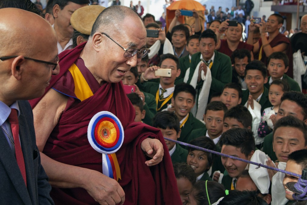 The Dalai Lama is welcomed by schoolchildren upon his arrival at the Tibetan Institute of Performing Arts in Dharmsala, India. Photo: AP