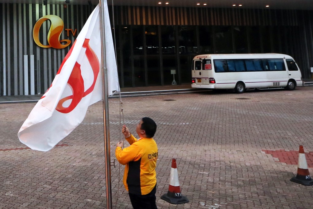 An employee raises a flag bearing the ATV logo outside the Asia Television Building in Tai Po. Photo: SCMP Pictures