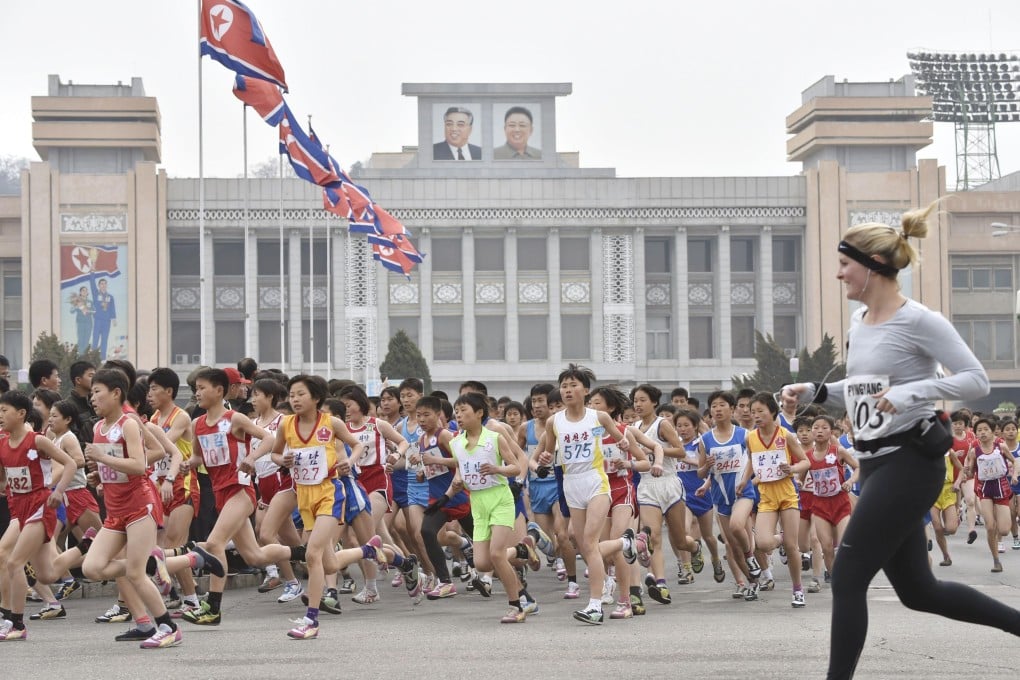 A foreign runner runs with local people during the annual marathon in Pyongyang. Photo: Kyodo