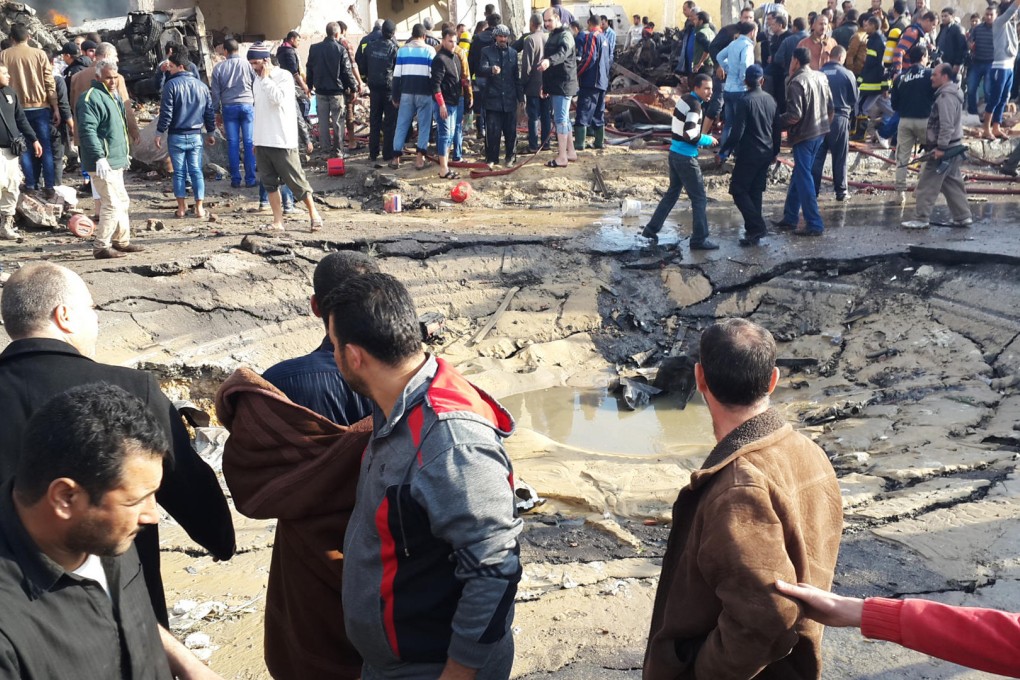 Egyptians gather around the crater formed when a bomb struck the police station in el-Arish, northern Sinai province, killing eight.Photo: AP