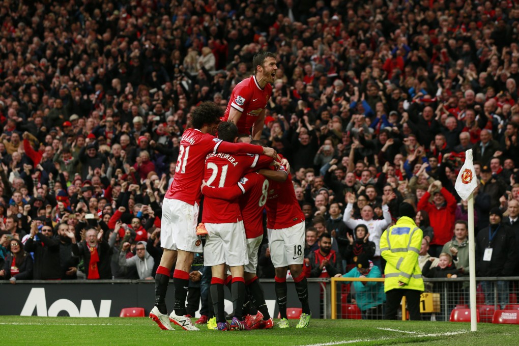 Kings of Manchester again: Michael Carrick climbs on top of his teammates who have engulfed Juan Mata after he scored United's third goal. Photo: Reuters
