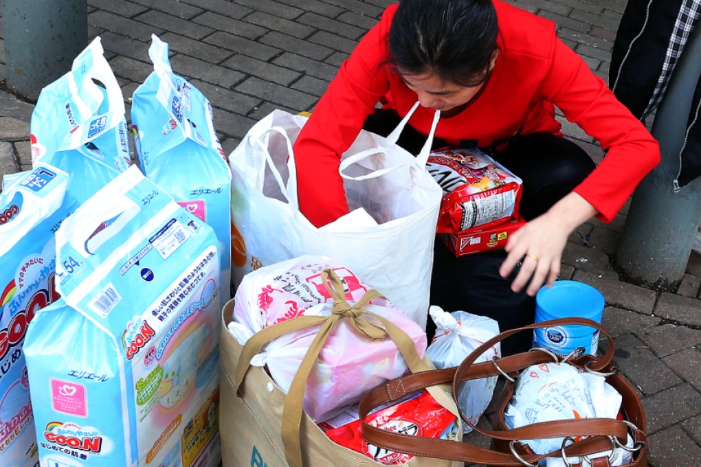 Parallel traders, such as these repackaging goods in Sheung Shui yesterday, will be allowed fewer visits to Hong Kong. Photo: K.Y. Cheng