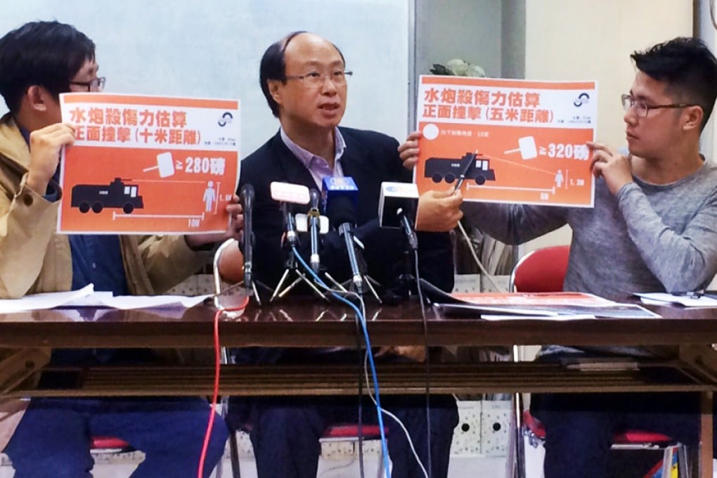 Albert Lai (centre) explains the effect that a water cannon can have on a protester. Photo: Samuel Chan