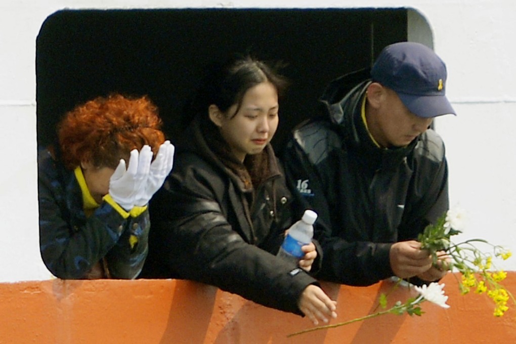 Relatives weep and offer flowers at the accident site. Photo: Kyodo