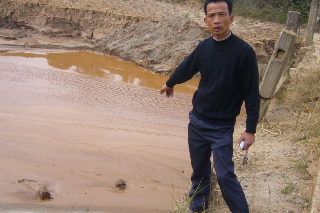 The bed of a brook in Banjiang village is polluted by waste water containing sulphur discharged from an illegal iron mine. The polluted brook joins the Dongjiang about 50 kilometres downstream.