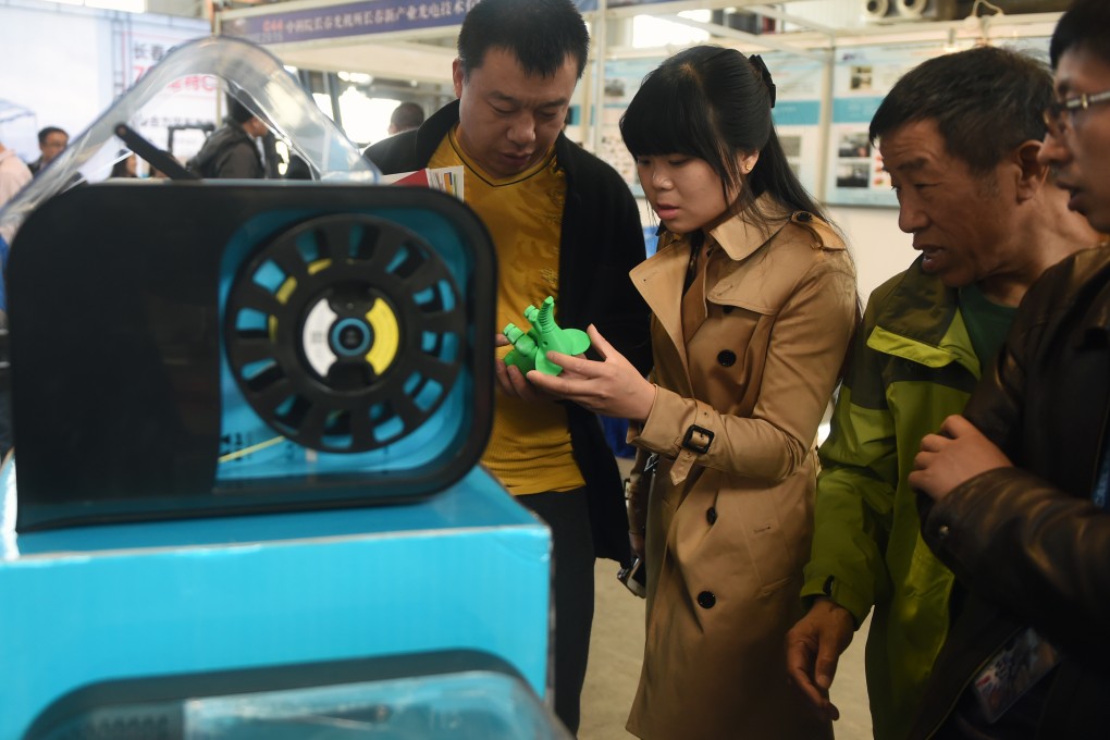 Visitors look at a 3D printer in China, with analysts saying it is time to establish a global investment agreement. Photo: Xinhua