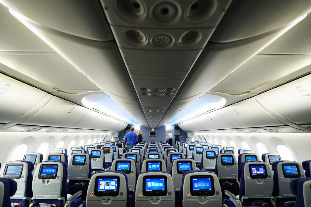 A staff walks through the United Airlines Economy Class with personal entertainment systems on the Boeing 787 Dreamliner at Los Angeles International Airport. Photo: AFP