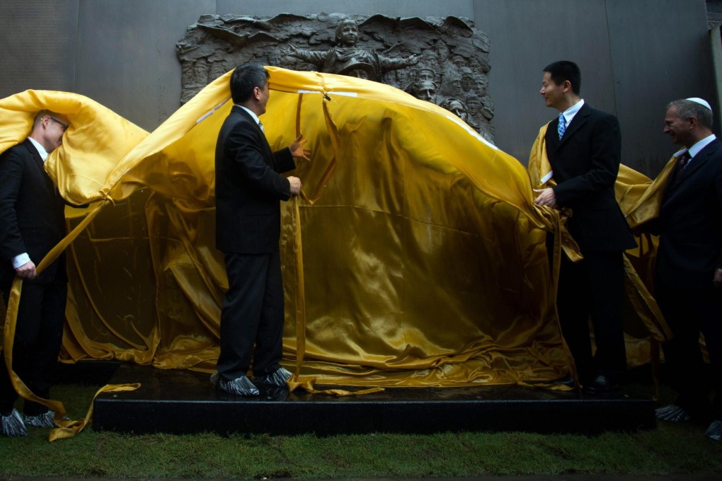 Yan Shuang (centre), deputy director general of the Shanghai Publicity Department, unveils a copper wall displaying the names of Jews who took refuge in Shanghai during the 1930s and 1940s.Photos: AFP, Alice Yan, Corbis