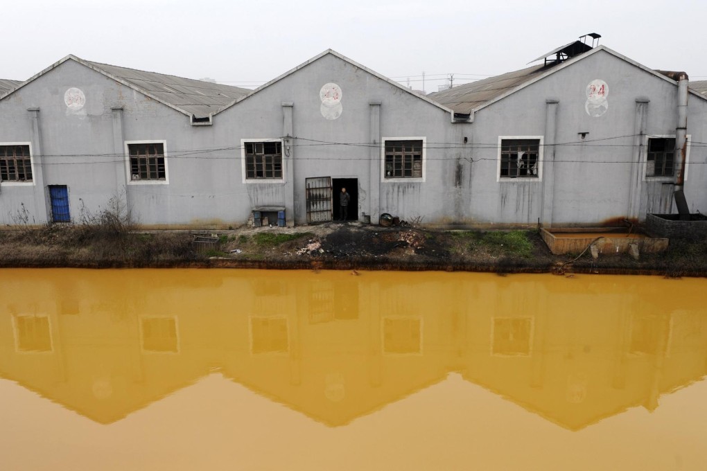 A polluted river runs past a factory in Jiaxing, Zhejiang province. China is banning water-polluting plants to try to reverse contamination of its rivers and underground supplies. Photo: Reuters
