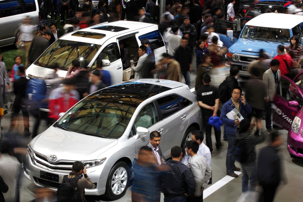Shoppers look over Toyota cars at an exhibition in China. Photo: Reuters