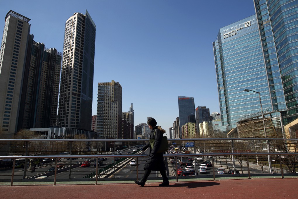 A woman walks past the Kaisa Plaza in Beijing. Photo: Bloomberg