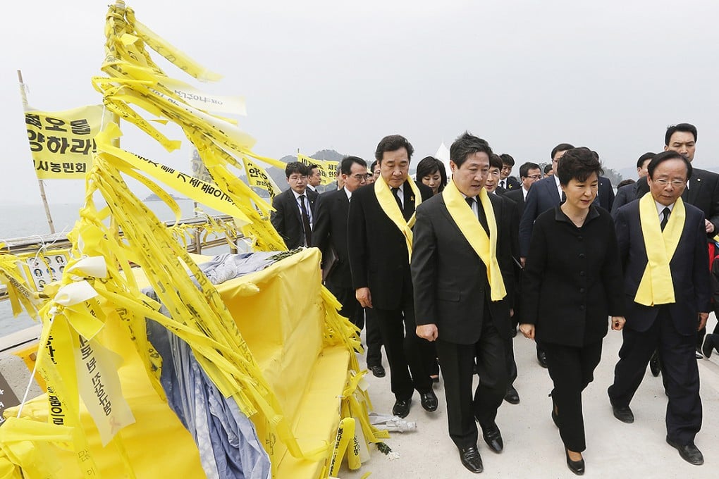 South Korean President Park Geun-hye, center front, passes by yellow ribbons tied with messages for the victims of the sunken ferry Sewol as she arrives to offer her condolences to the bereaved relatives of the victims at a port in Jindo. Photo: AP