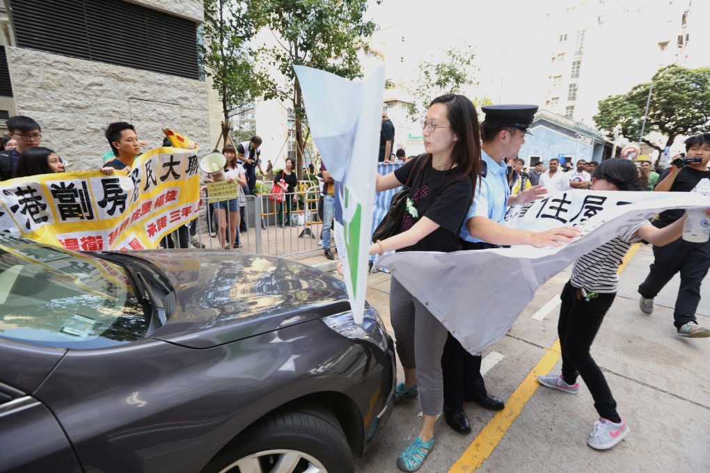 Protesters block the car of URA chairman Victor So in Sham Shui Po yesterday to advocate greater social responsibility. Photo: Nora Tam