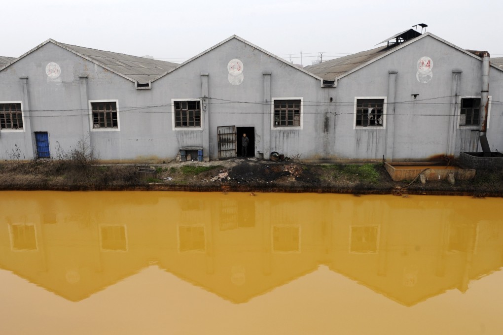 A polluted river runs past a factory in Jiaxing, Zhejiang province. The mainland is banning water-polluting plants. Photo: Reuters