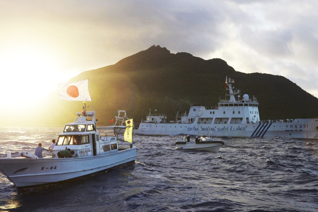 The large Chinese marine surveillance ship Haijian 51 sails through smaller Japanese coast guard vessels off disputed islands in the East China Sea in July, 2013. Photo: Kyodo/Reuters
