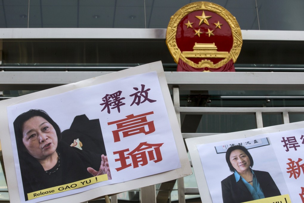 Portraits of Chinese journalist Gao Yu are seen in front of the national emblem of China during a demonstration calling for the release of Gao, outside the Chinese liaison office in Hong Kong. Photo: Reuters