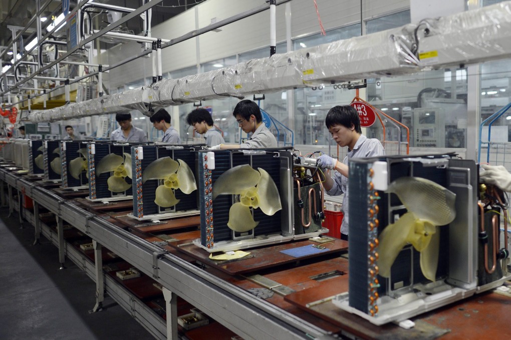Workers assemble air conditioners at a Gree factory. Now the firm has joined the smartphone market. Photo: EPA