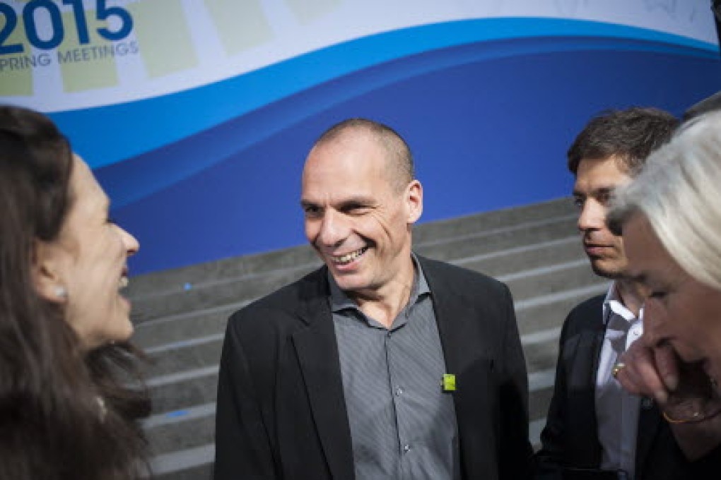 Greek Minister of Finance Yanis Varoufakis chats with other delegates as he makes his way to a session during the IMF and World Bank Spring Meetings. Photo: EPA