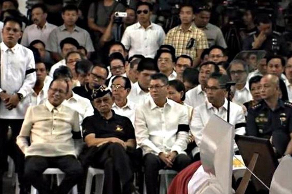 Aquino apparently smiles at the wake of 44 police commandos who died in a botched anti-terror operation in January.