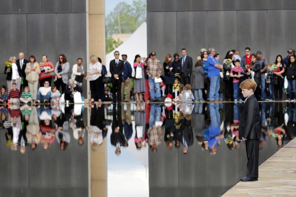 A child stands at the reflecting pool as the crowd gathers during a ceremony at the Oklahoma City National Memorial &amp; Museum.Photo: AP