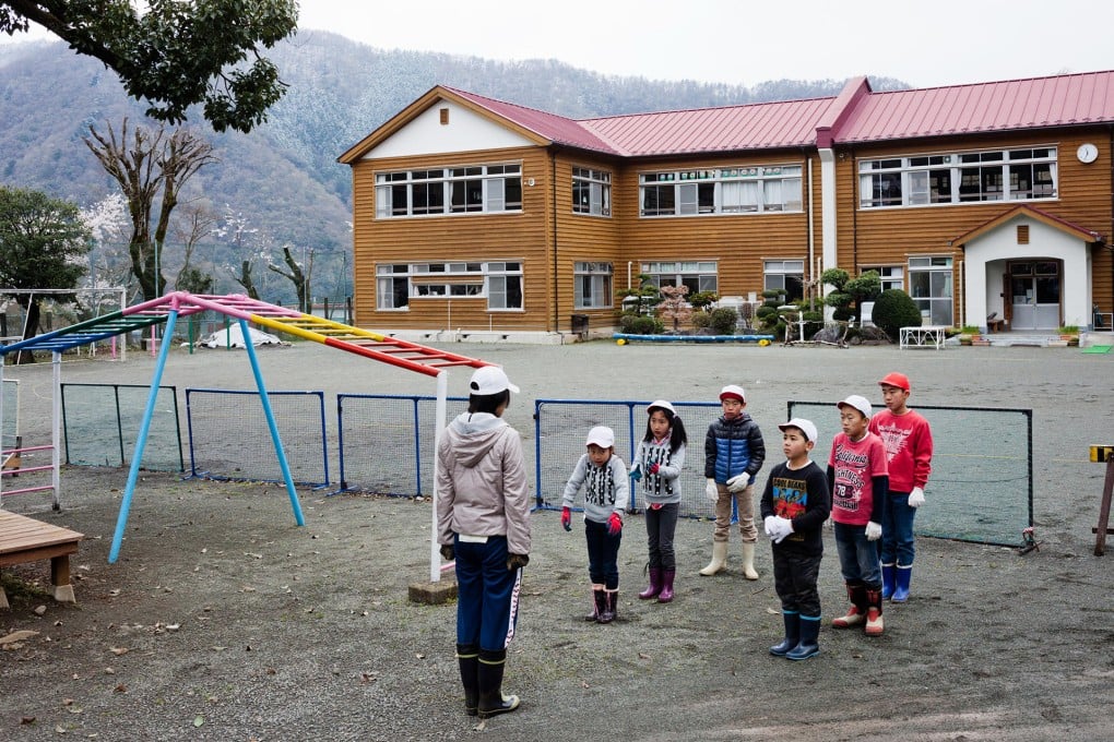 Aone elementary students line up in front of a teacher before leaving school to plant seeds in a potato field nearby. Photo: Washington Post