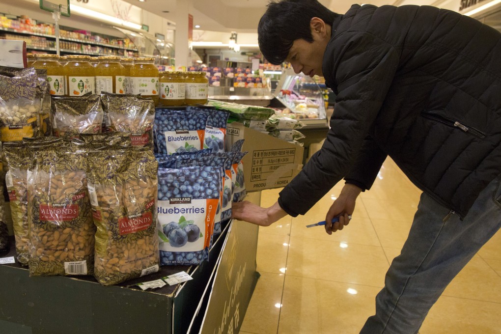 A worker in a Beijing store stacks bags of California almonds. Photo: A{P