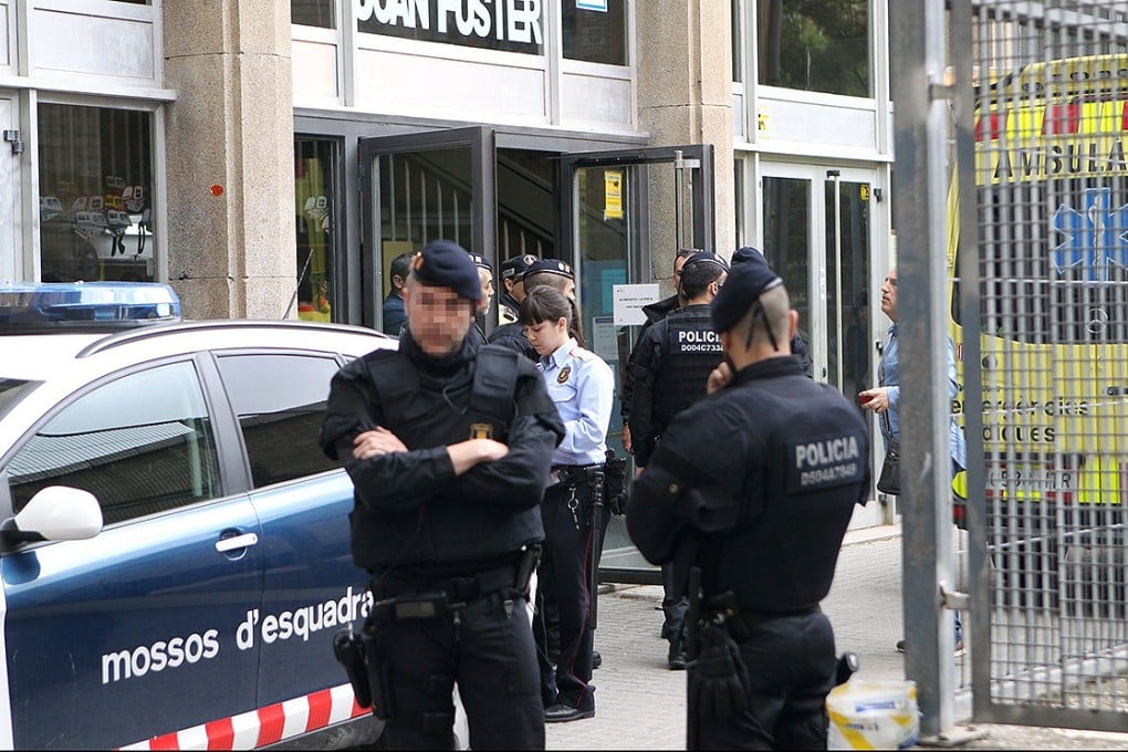 Policemen stand guard outside the Instituto Joan Foster in Barcelona after a student burst into the school wielding a crossbow and knife. Photo: EPA