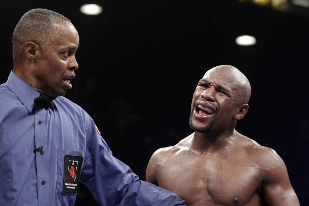 Referee Kenny Bayless holds back Floyd Mayweather  in his bout against Marcos Maidana in September last year in Las Vegas. Mayweather dominated with a 12-round unanimous decision to retain his WBA welterweight belt and WBC welterweight and super welterweight world titles. Photo: AFP