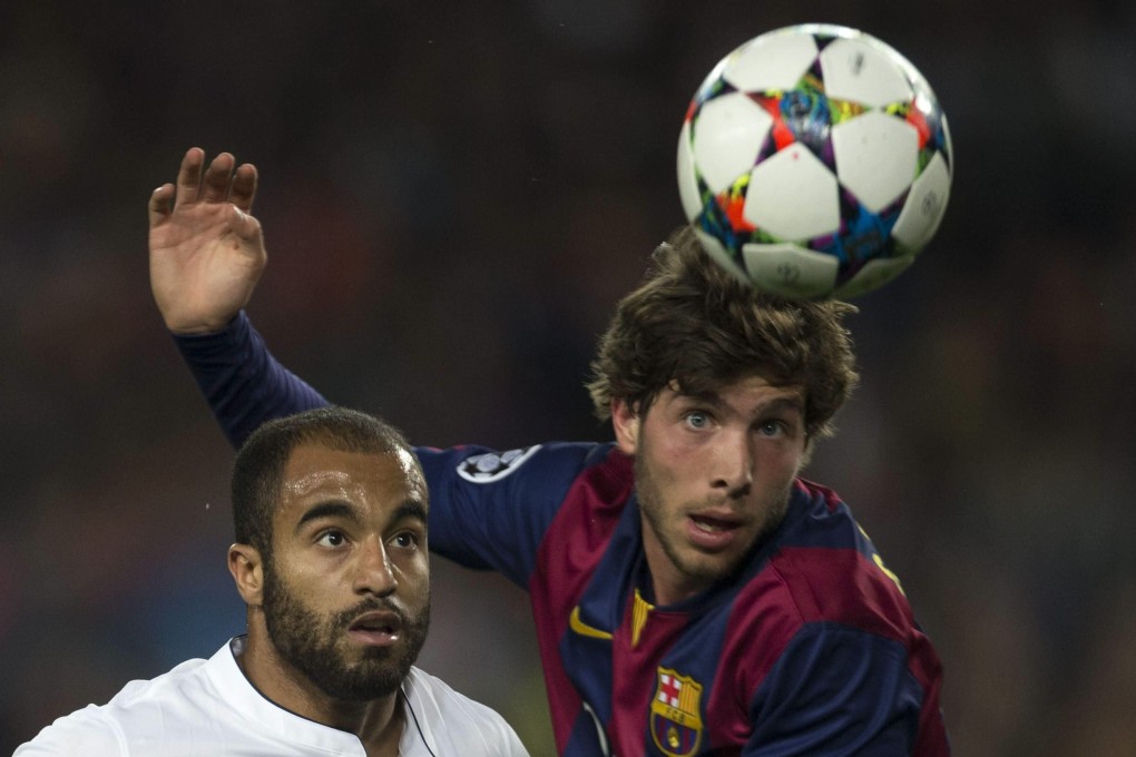 Paris Saint-Germain midfielder Lucas Moura is beaten to the ball by Barcelona counterpart Sergi Roberto. Photo: EPA