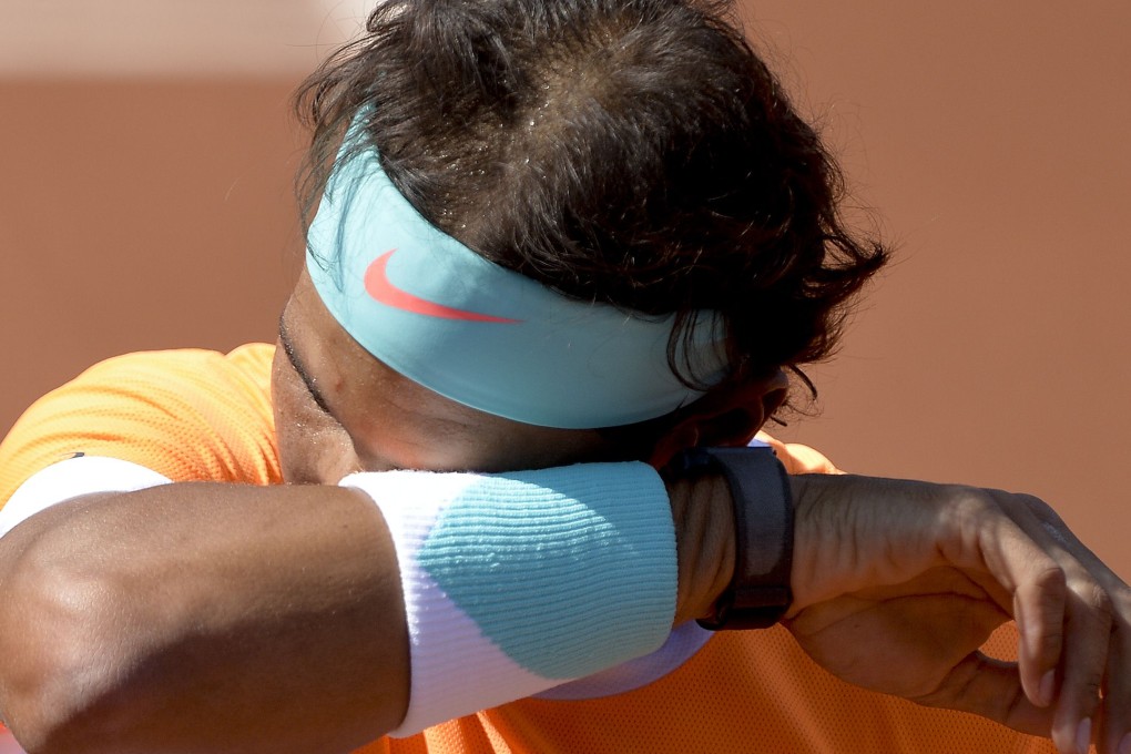 Spaniard Rafael Nadal wipes his head after a match against Italian tennis player Fabio Fognini at the "Conde de Godo" tennis tournament in Barcelona. Photos: AFP