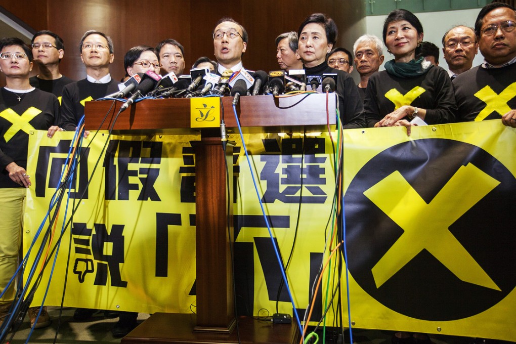 Pan-democratic lawmakers speak to the media after walking out on Chief Secretary Carrie Lam as she launches the government's political reform package in Legco. Photo: EPA