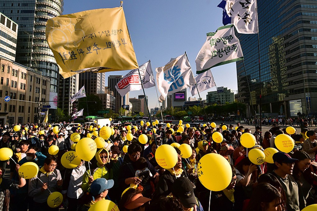 South Korean protestors march demanding for a fully independent inquiry into last year's Sewol ferry disaster in downtown Seoul on Saturday. Photo: AFP