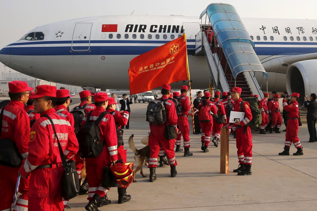 Members of Chinese International Search and Rescue Team and their rescue dogs board a charted plane to Kathmandu. Photo: Reuters