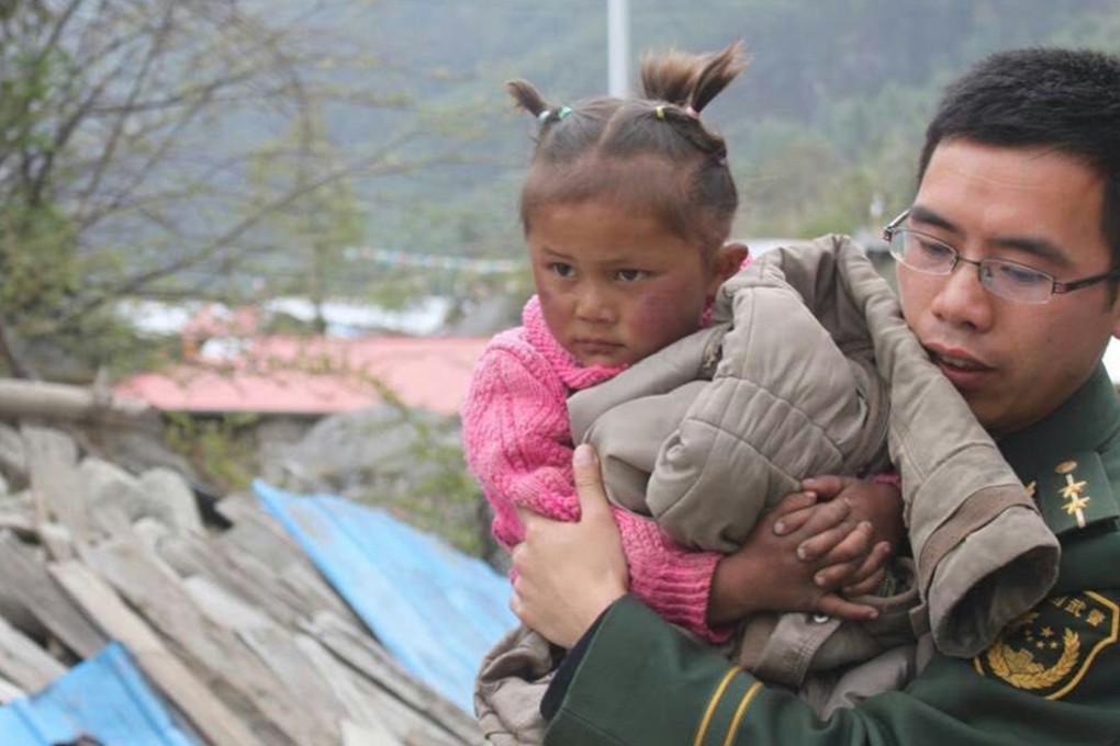 A soldier helps a child evacuate in Gyirong county in Xigaze, Tibet, on the weekend. Photo: TNs