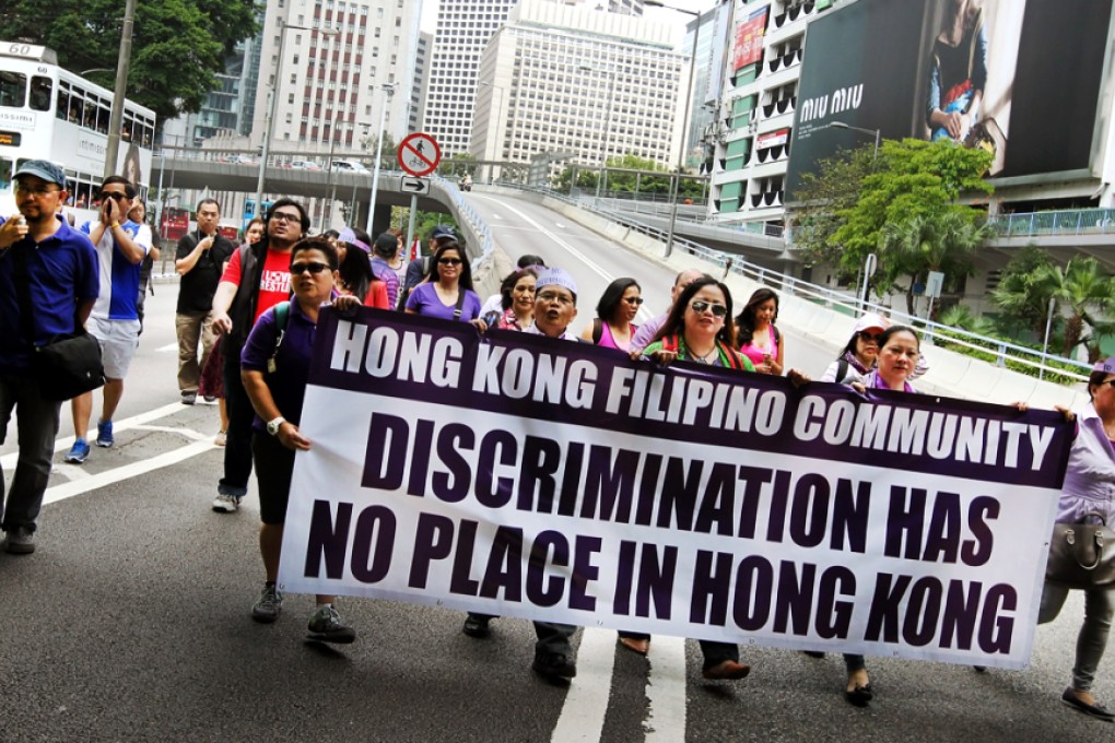 Protesters march with banners in Central on Sunday over Regina Ip's comments about Filipino maids sleeping with their expat bosses. Photo: Franke Tsang