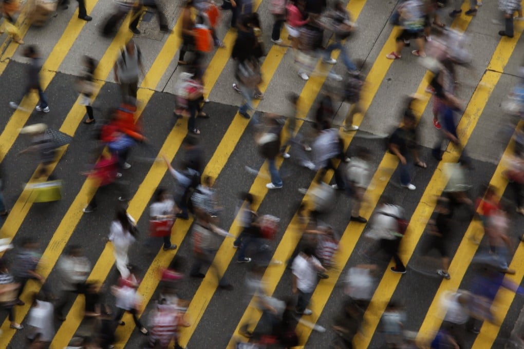 People cross a street in Mong Kok district in Hong Kong. Photo: Reuters