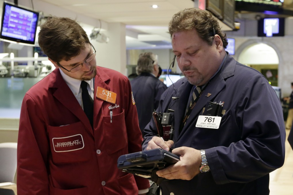 Traders jot down orders on the floor of the New York Stock Exchange in the United States. Photo: AP