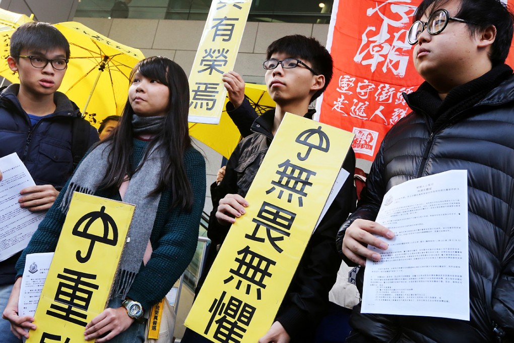 Members of Scholarism (from left) Oscar Lai Man-lok, Agnes Chow Ting,  convener Joshua Wong Chi-Fung and Derek Lam Shun-hin, hold banners before reporting to the Police headquarters in Wan Chai in January. Photo: Sam Tsang