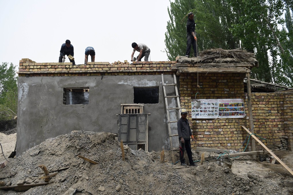 Workers build a house in the town of Elishku, Xinjiang. The township was the scene of a bloody clash in July 2014. Photo: AFP