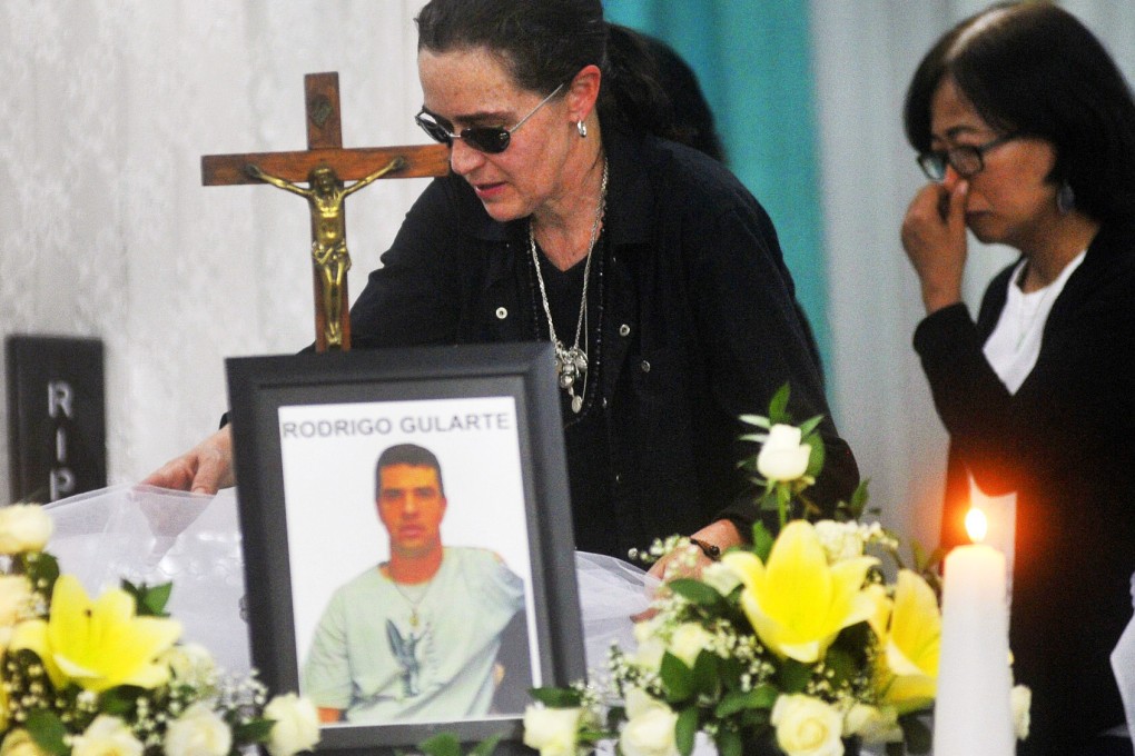 Angelita Muxfeldt, left, a cousin of Brazilian death row convict Rodrigo Gularte, touches Gularte's coffin at a funeral home in Jakarta. Photo: AP